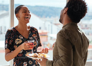 Woman and man holding drinks and laughing